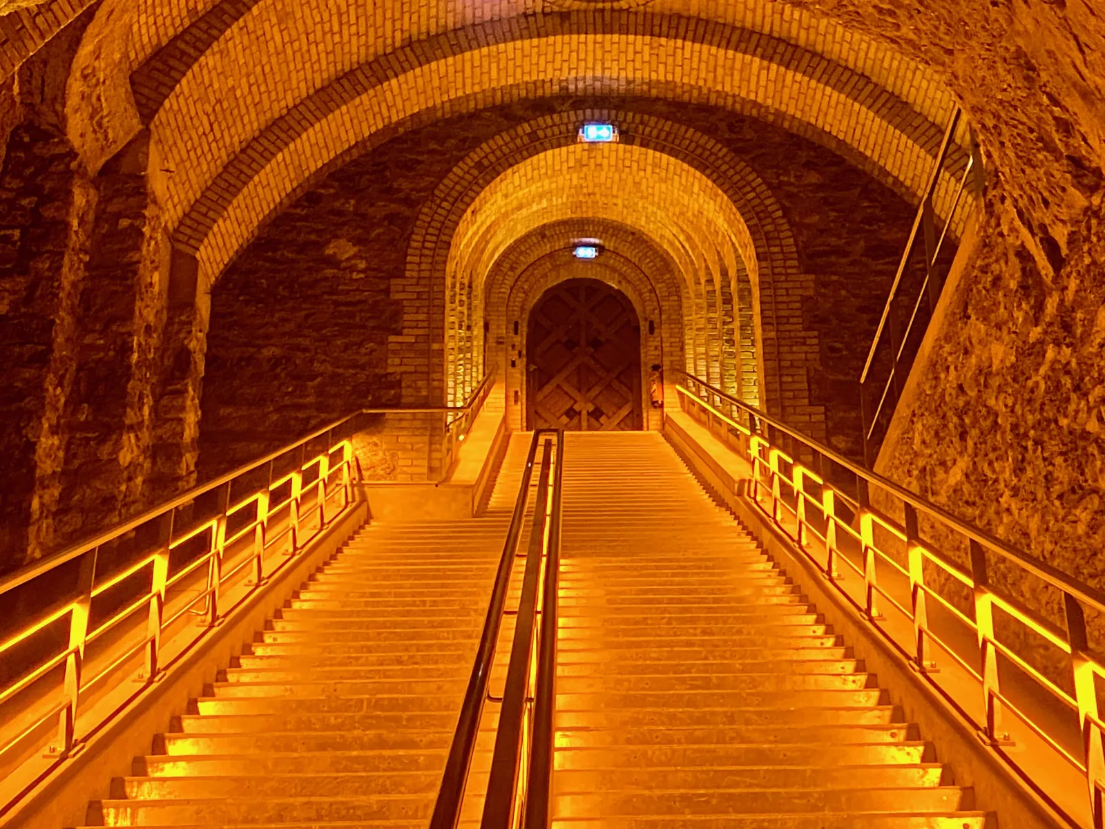 A lit staircase descending into the chalk cellars beneath a Champagne house