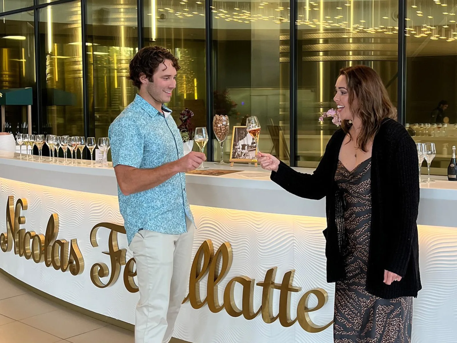 Two guests at the curved Nicolas Feuillatte tasting bar with flutes lined up