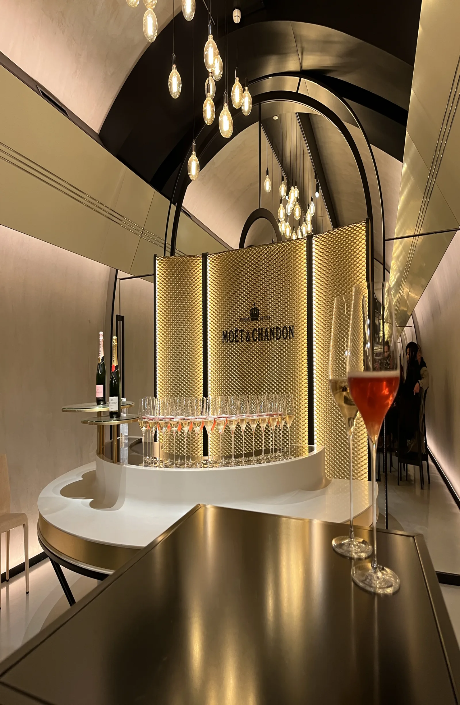 The lit Moët & Chandon tasting counter with flutes and a glass of rosé